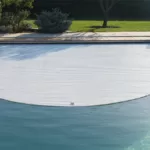 Volet de piscine immergé se déroulant dans la piscine pour le nettoyage, en journée à Montpellier.